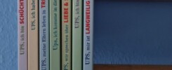 Sieben Bücher aus der Ups-Reihe vom Humboldtverlag stehen nebeneinander aufgereiht vor einer blauen Wand.